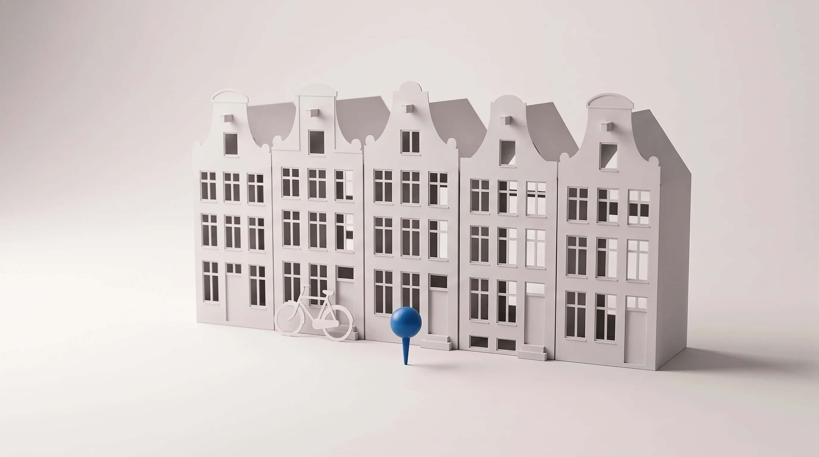 Papieren maquette van vijf grachtenpanden met een fietsje en één blauwe kaartspeld ervoor