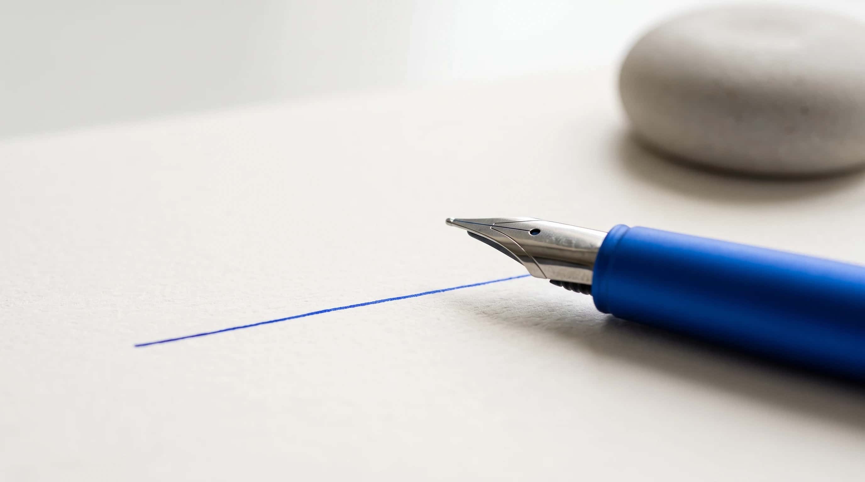 Macro van een blauwe vulpen die één rechte inktlijn op blanco papier trekt
