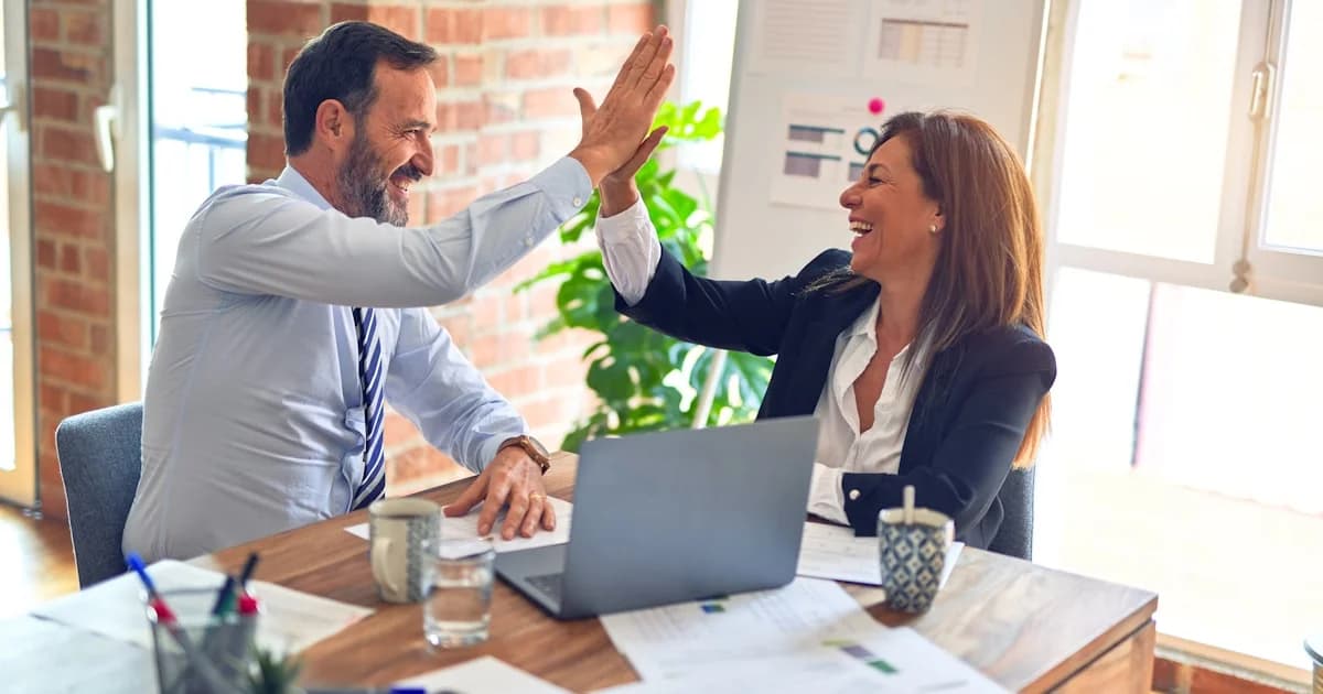 Modern kantoor met medewerkers die samenwerken via Microsoft 365 en Teams op laptops