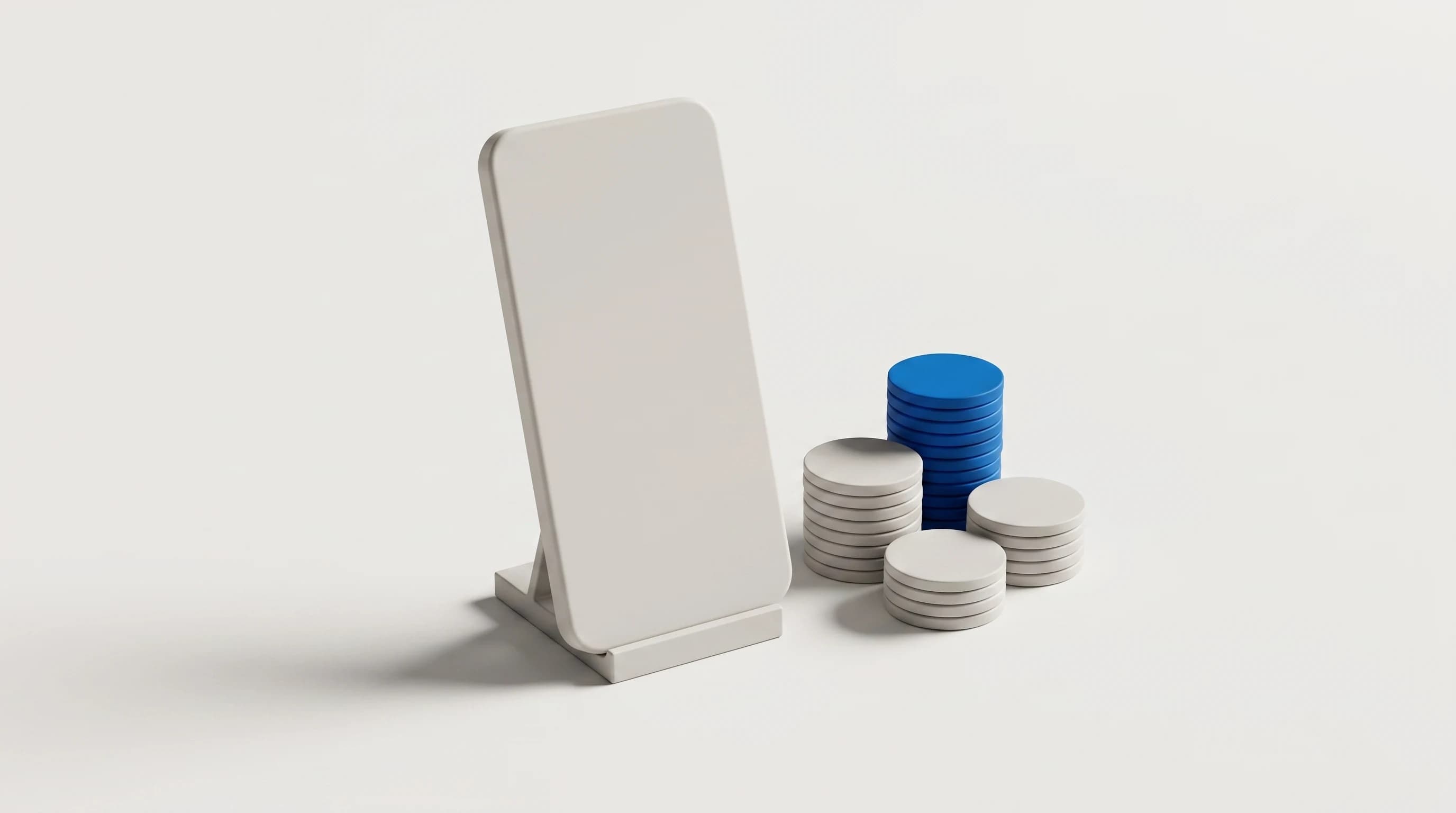 Blanco smartphonevormige plaat op een standaard naast drie stapels schijfjes, de hoogste stapel in blauw
