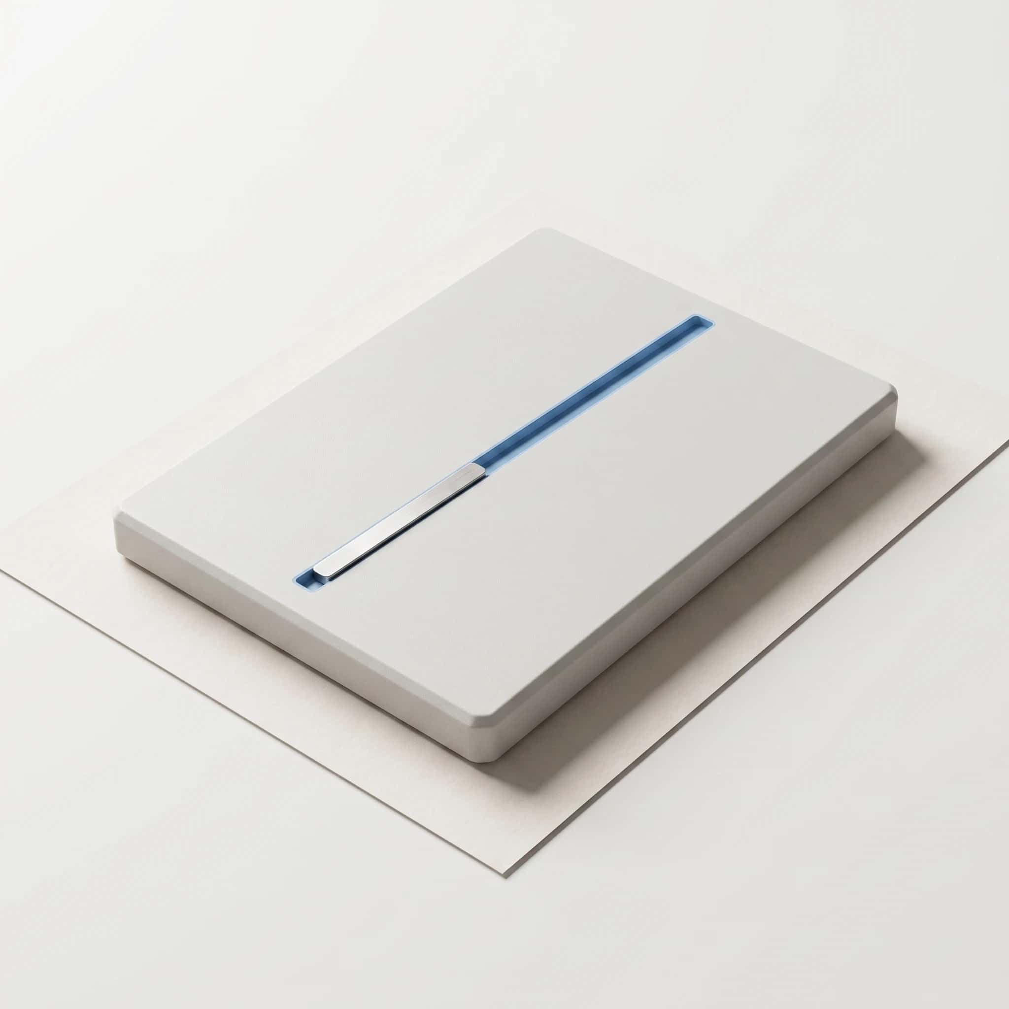 Lichtgrijze matte plaat met een smalle blauwe groef er dwars overheen en een aluminium schuifmarkering in die groef