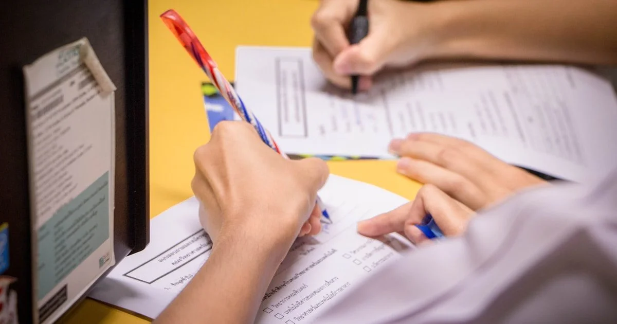 Persoon die op een checklist schrijft als symbool voor AI Act compliance en praktische stappen voor naleving