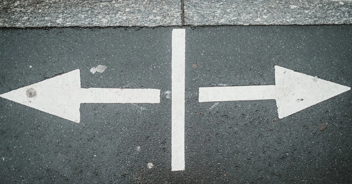 Houten pad dat in twee richtingen splitst — metafoor voor het kiezen van de juiste AI assistent met een beslisframework