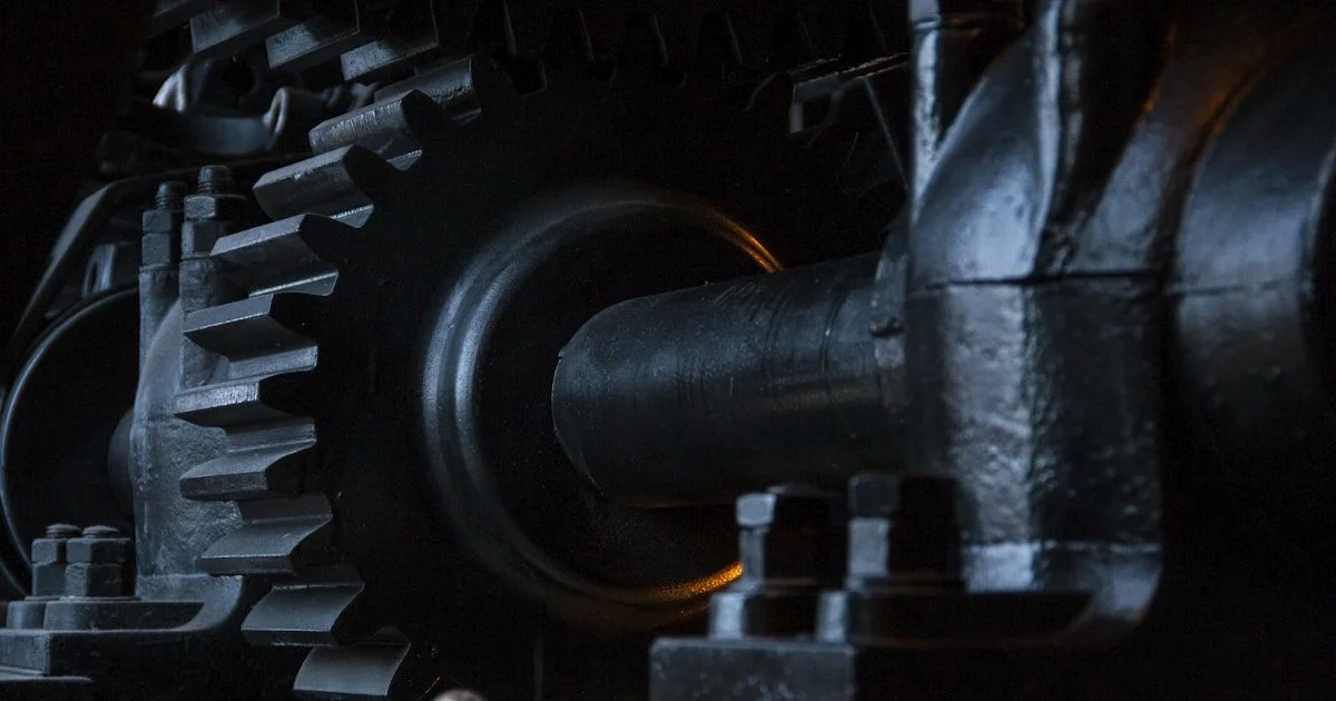 Close-up van zwarte metalen tandwielen — contrast tussen traditionele mechanische automatisering en moderne AI-systemen