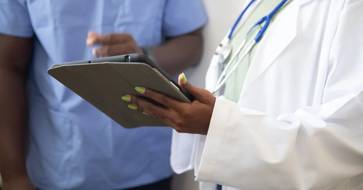 Arts toont patiënt medische informatie op een digitale tablet tijdens triage consult