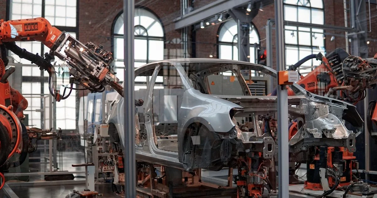 Robotarmen werken aan een voertuig in een geautomatiseerde fabriek voor voorspellend onderhoud