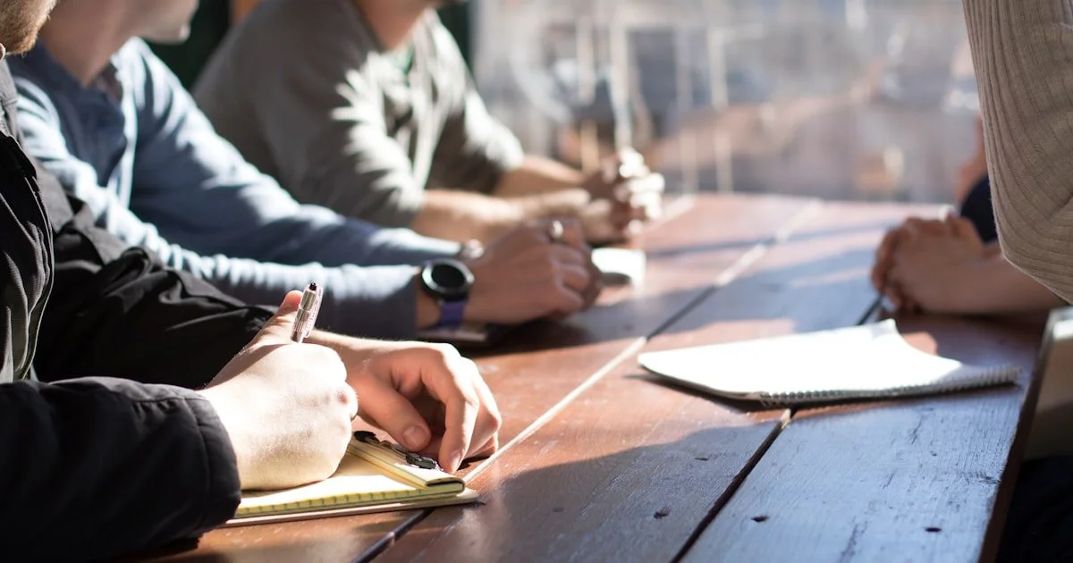 Team in vergaderruimte bespreekt samen plannen en strategie, symbool voor change management bij AI-transformatie