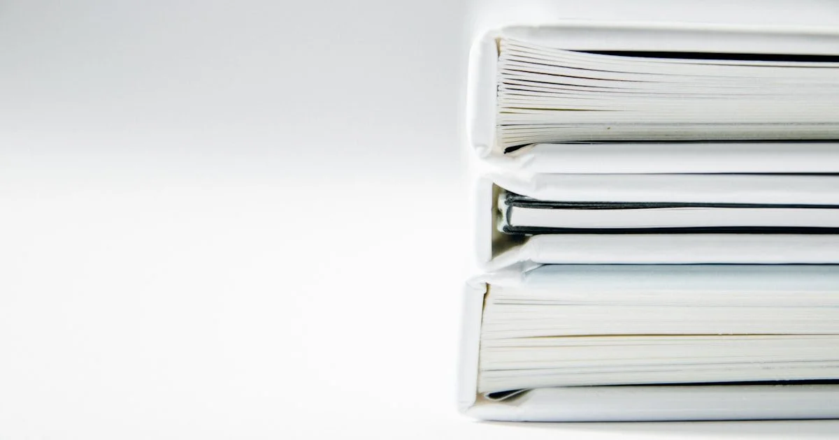 Stapel dikke mappen en documenten die wachten op digitalisering via OCR en AI