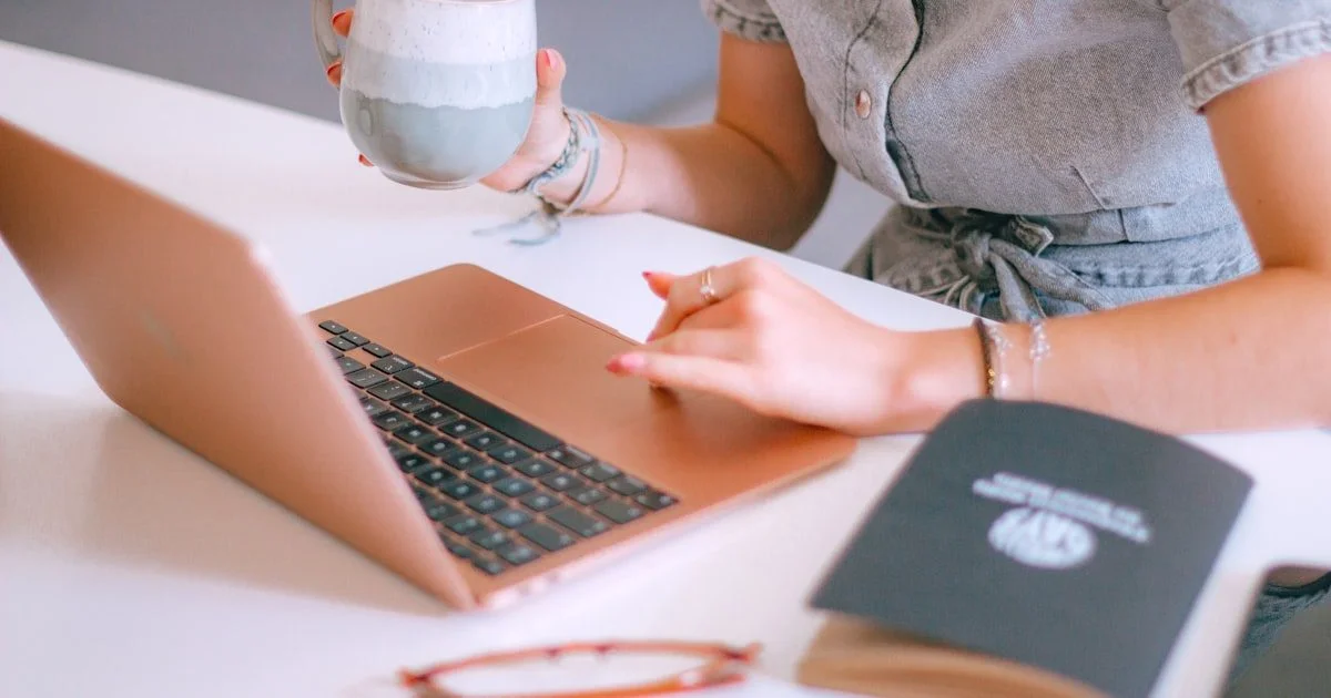 Vrouw werkt aan laptop met koffie — content creator die AI-schrijftools zoals Jasper AI gebruikt voor marketing