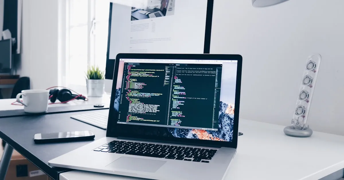Programmeur die code schrijft op een laptop in een creatieve werkruimte, website development
